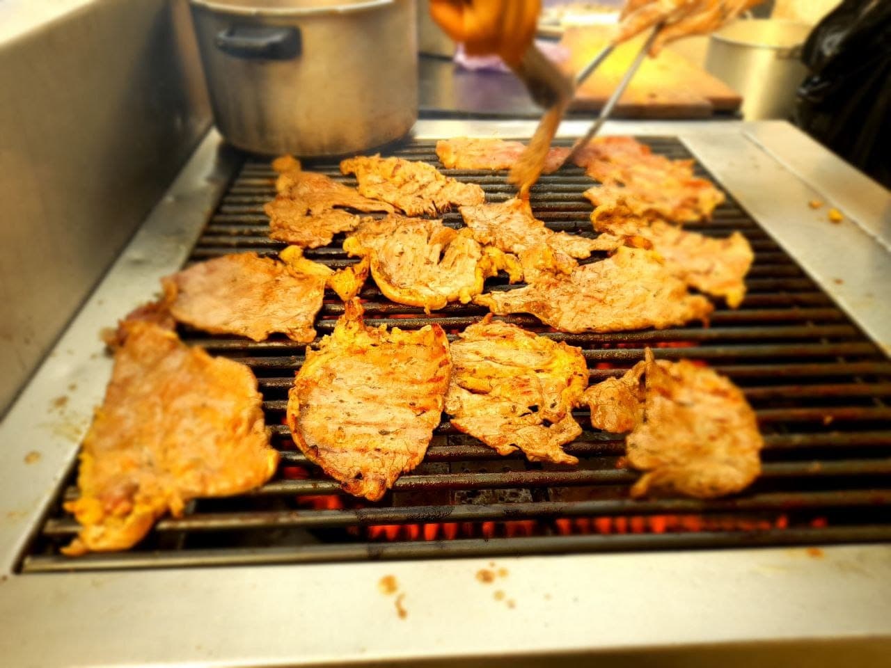 Carne asándose sobre la parrilla al carbón durante un evento de La Silenciosa