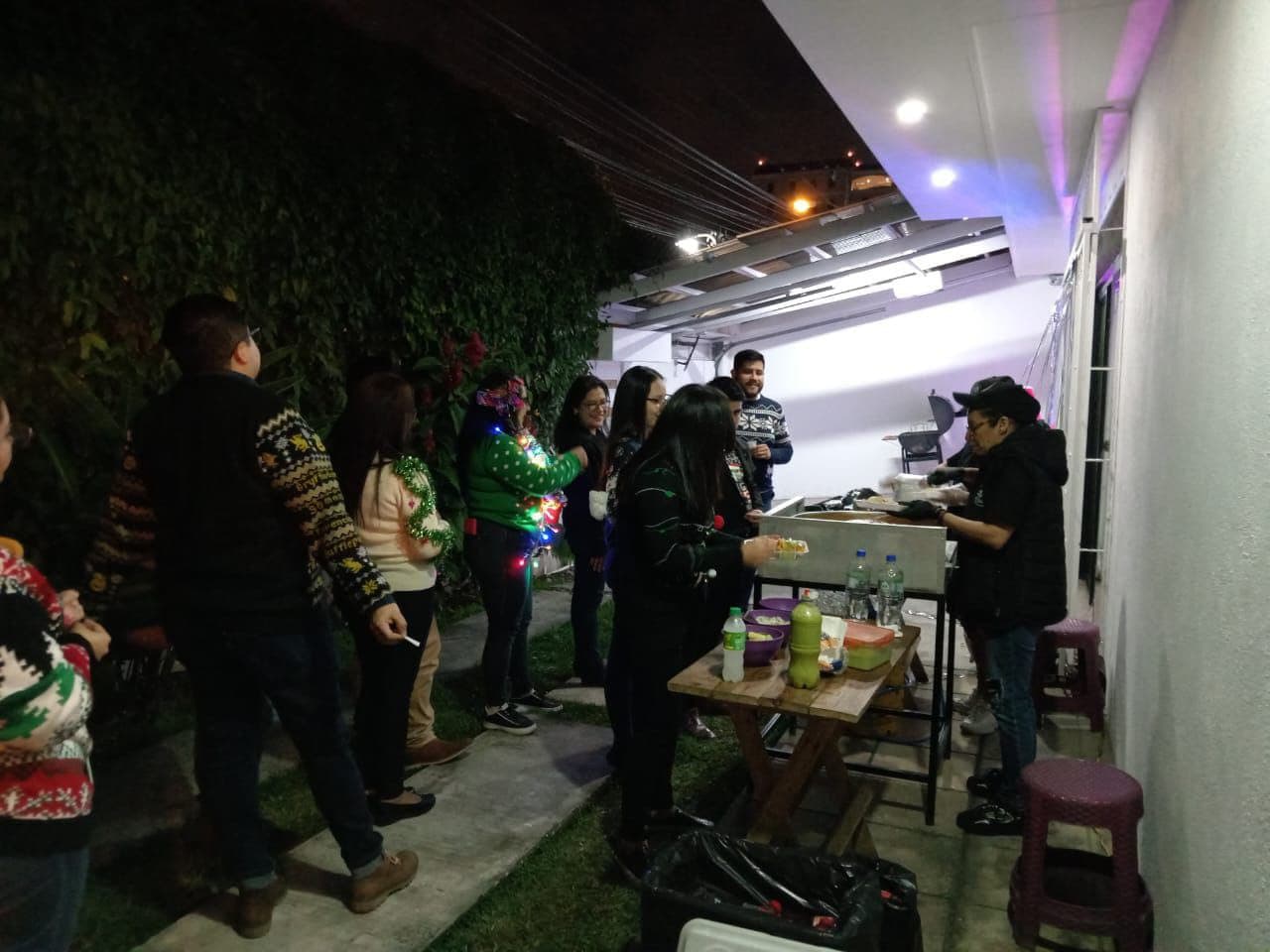Invitados de una fiesta nocturna haciendo fila para ser servidos desde la carreta